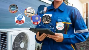 An HVAC technician stands next to heating and cooling equipment while holding a tablet displaying graphs and analytics. Digital marketing icons blend subtly into the background.